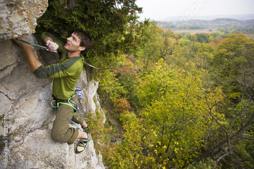 A young man climbs the Abyss 5.10b, Rattle Snake Point, ON photo