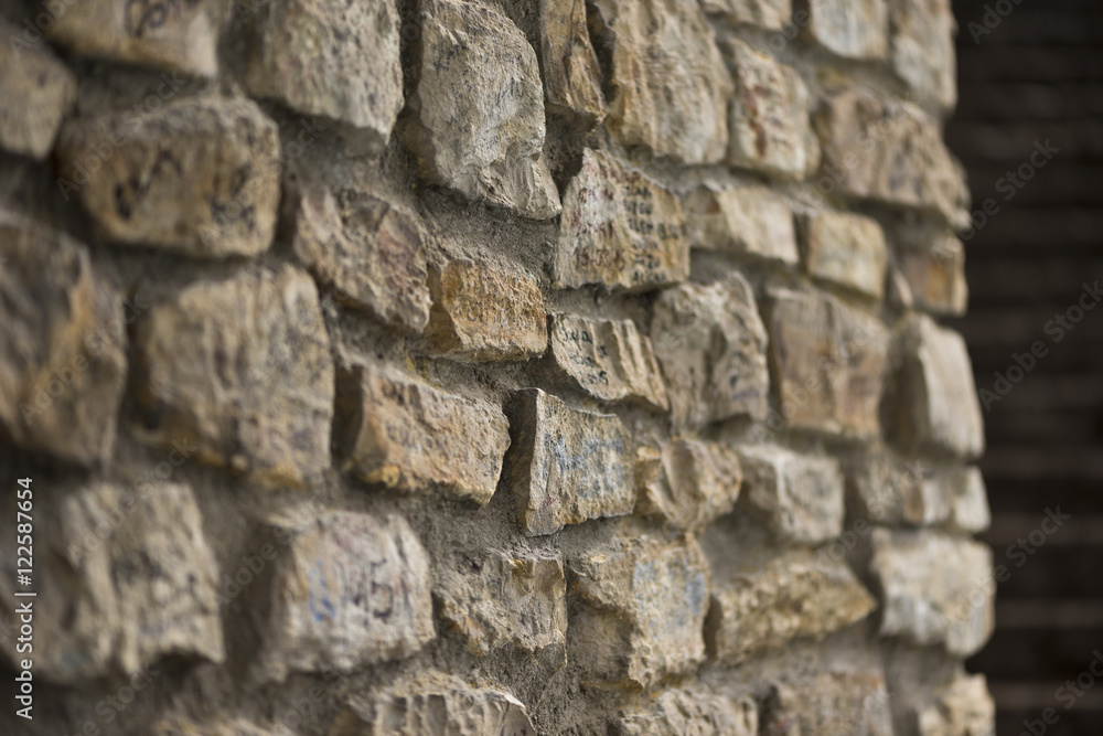Side view of stone wall,with naughty alphabet , selective focus Side view of stone wall,with naughty alphabet , selective focus