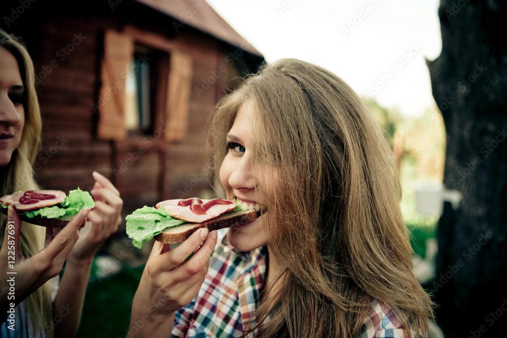 Pretty girl in plaid shirt bites a sandwich Pretty girl in plaid shirt bites a sandwich