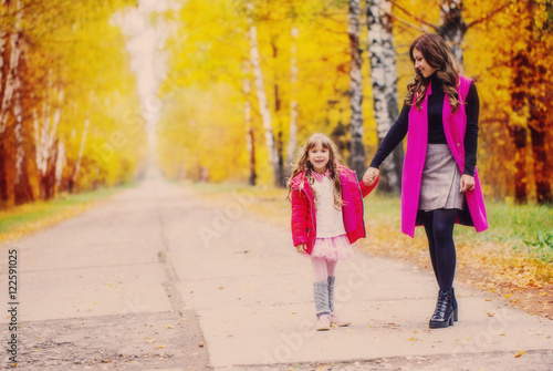 Mother and her little daughter at beautiful autumn park