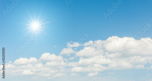Blue sky with clouds and sun reflection