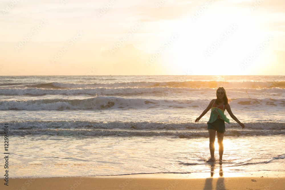 woman walking on the beach, sunshine in the morning