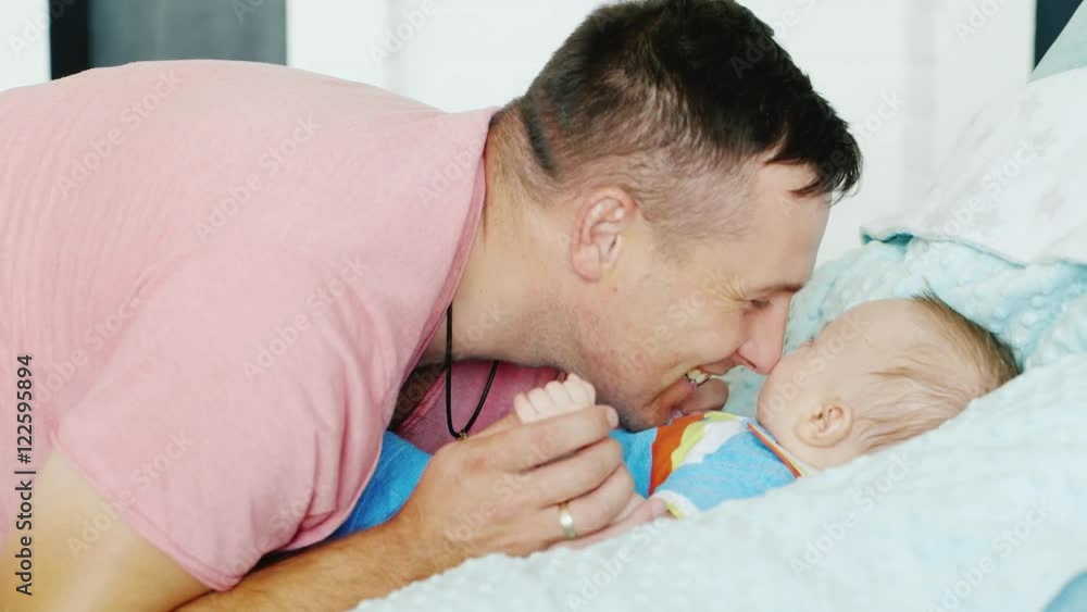 Happy fatherhood. Young attractive man smiles at his young son to play with him Happy fatherhood. Young attractive man smiles at his young son to play with him
