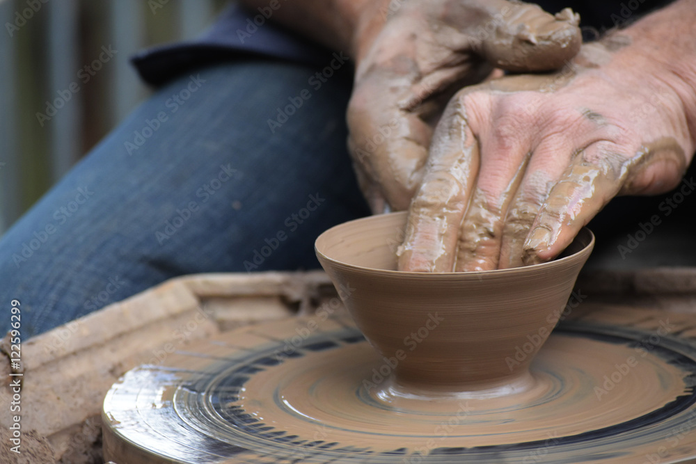 potter's hands creating a new ceramic of clay on the wheel