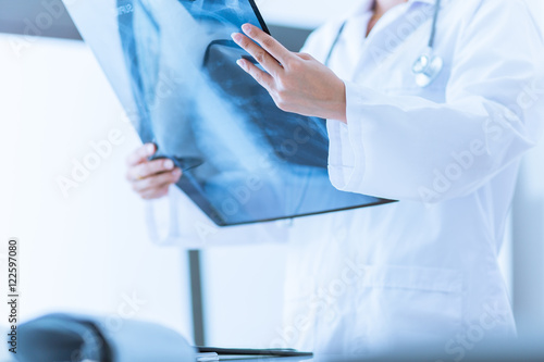 Woman Doctor Looking at X-Ray Radiography in patient's Room