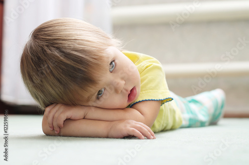 Papier peint Little girl lying on the floor on arms