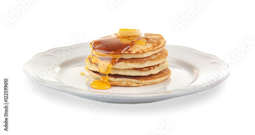 Tasty pancakes with honey and butter on plate, isolated on white