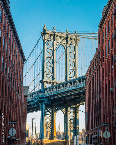 Manhattan bridge in old narrow Brooklyn street, New York City, U