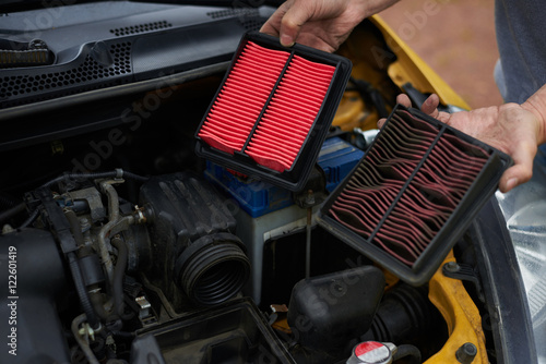 Comparison new and used air filter for car with engine bachground. photo