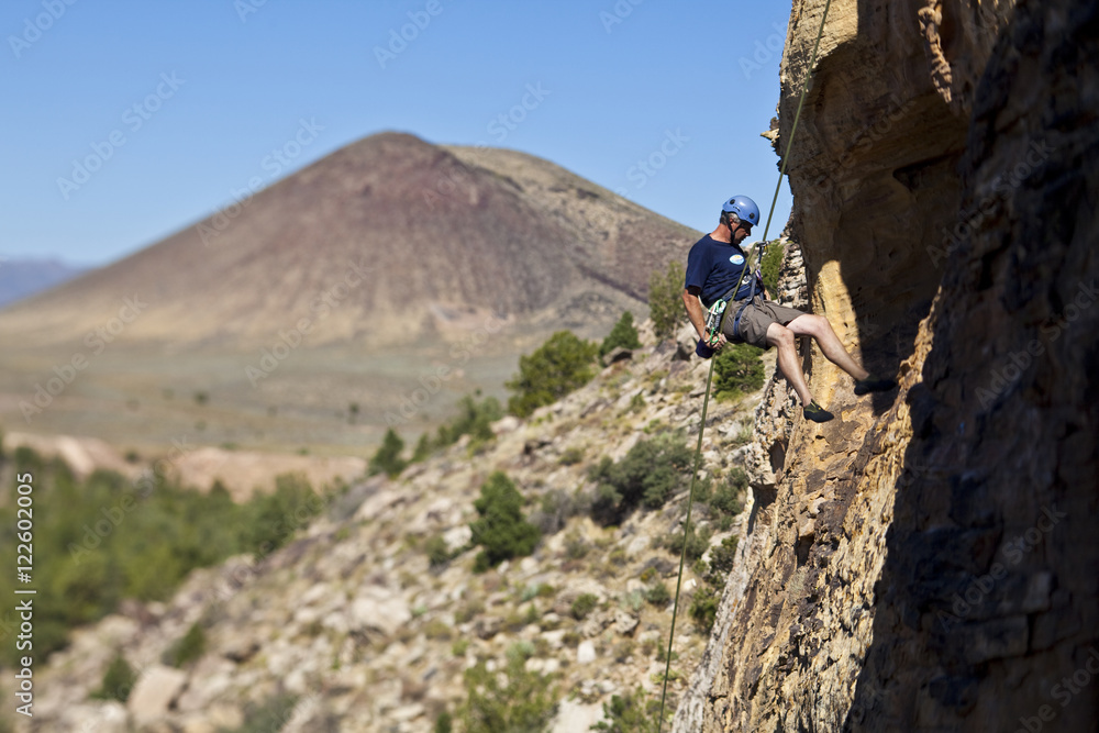 A man rappelling after rock climbing in St. George, Utah A man rappelling after rock climbing in St. George, Utah