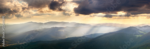 Panoramic View of the Mountains with Majestic Sunbeams and Clo © Taiga