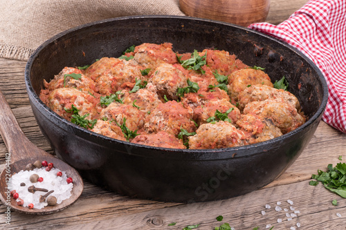 meat balls with herbs in pan on wooden rustic background.