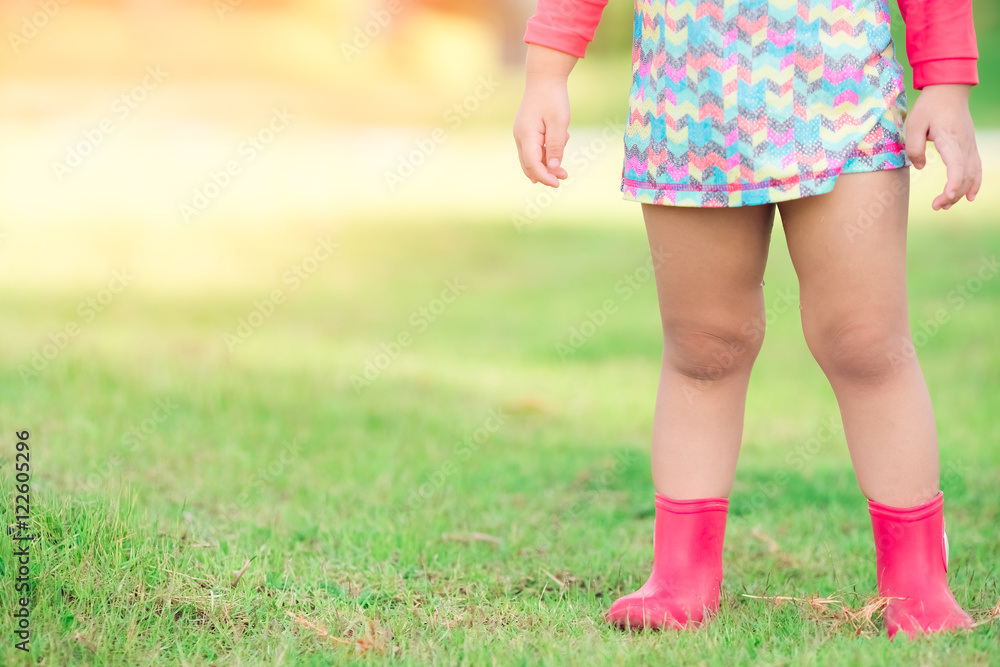 little girl legs wearing pink boots and swimming suit on green grass, Outdoor Concept little girl legs wearing pink boots and swimming suit on green grass, Outdoor Concept