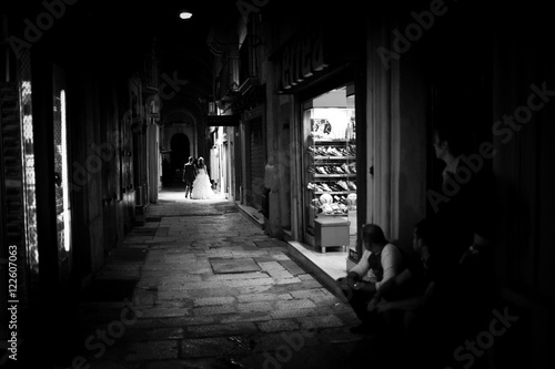 Black and white  photo of people standing on the street and watc