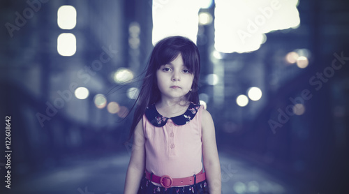 Bokeh background with small girl standing with her flying hair