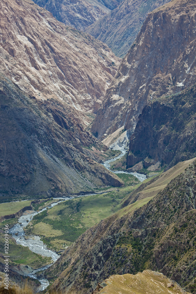 Rocky deep gorge and the mountain river in Tien Shan, Kyrgyzstan Rocky deep gorge and the mountain river in Tien Shan, Kyrgyzstan