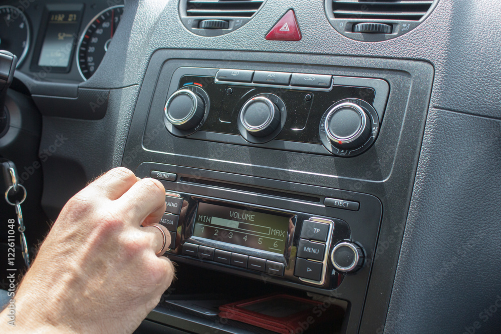 Fototapeta premium hand turns the car radio