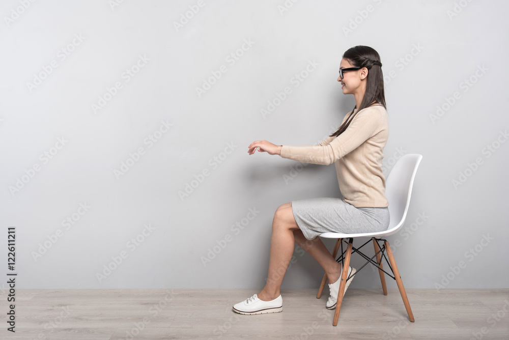 Fototapeta premium Positive woman sitting in the chair
