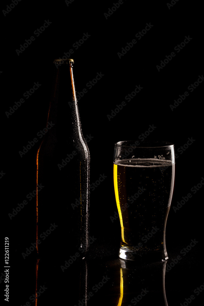 Beer bottle and glass silhouette isolated on black background Beer bottle and glass silhouette isolated on black background
