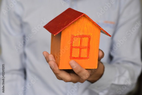 Businessman holding home model. Loan and real estate concept