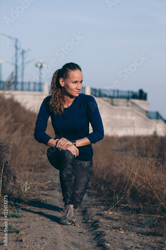 Fototapeta Naklejka Na Ścianę i Meble -  Young woman stretching before her run outdoors