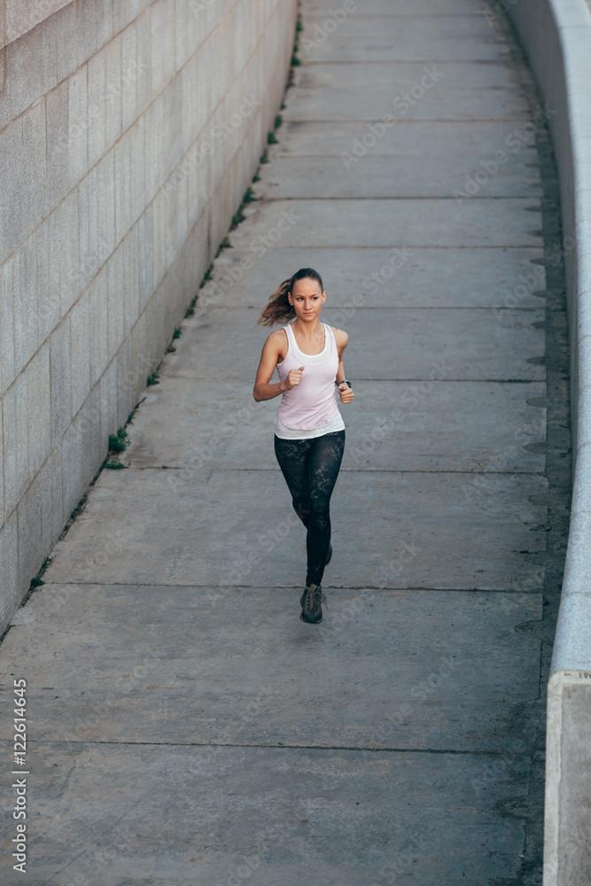woman running in concrete urban scape woman running in concrete urban scape