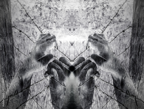 Valokuva Artistic surreal tortured hands grasping desperately barbed wire (infrared)