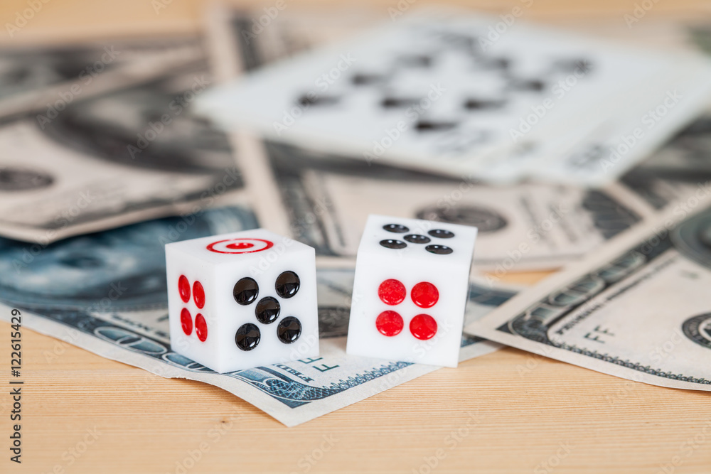 Two dices on wood table with US dollar and card Two dices on wood table with US dollar and card