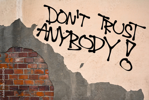 Do not Trust Anybody - Handwritten graffiti sprayed on the wall, anarchist aesthetics. Appeal to be suspicious. Distrust to others because of untrustworthy unreliability photo