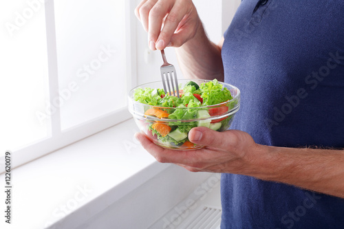 Fotografie Unrecognizable man has healthy lunch, eating diet vegetable sala