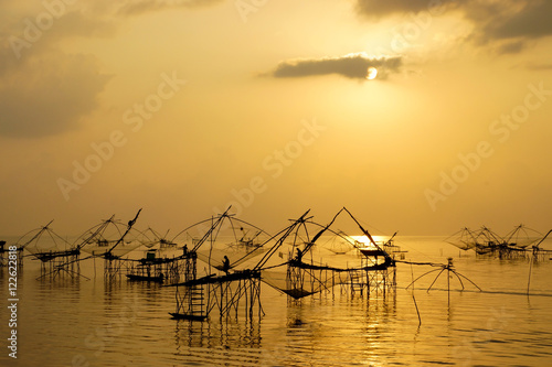 Silhouette of bamboo machinery in the lake. South of Thailand. © noppharat