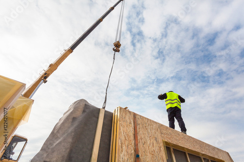 Εκτύπωση καμβά Roofer builder worker with crane installing structural Insulated Panels SIP
