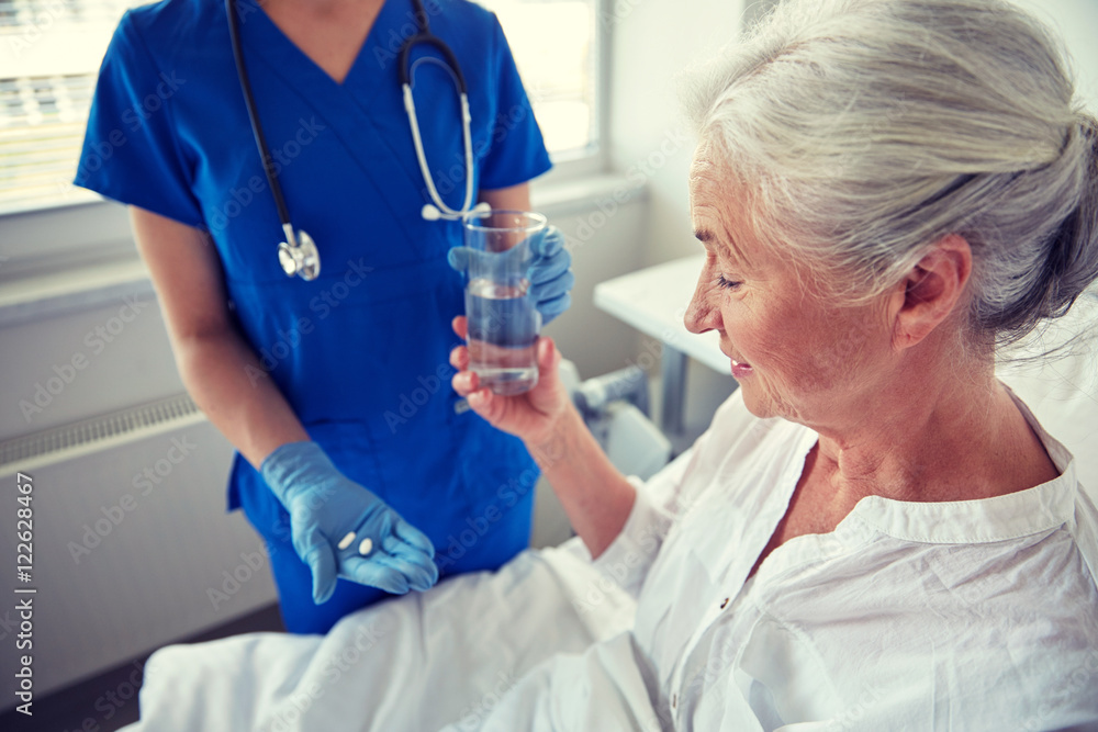nurse giving medicine to senior woman at hospital nurse giving medicine to senior woman at hospital