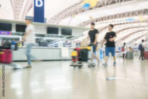 Blurred image of people traveling at airport terminal, People checking in at airport terminal with motion blur