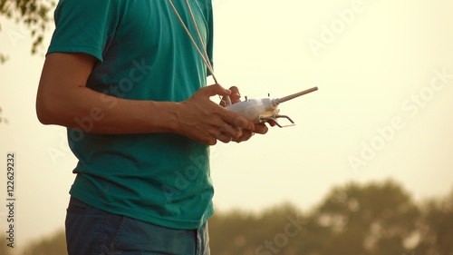 Man using drone RC remote at sunset