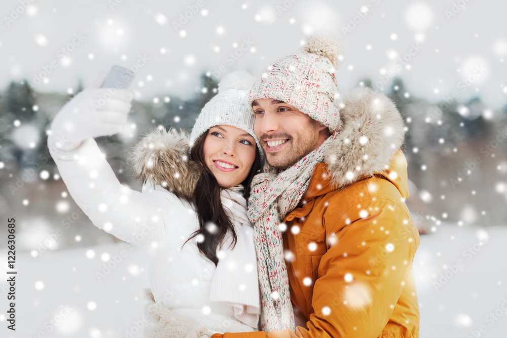 happy couple taking selfie by smartphone in winter happy couple taking selfie by smartphone in winter