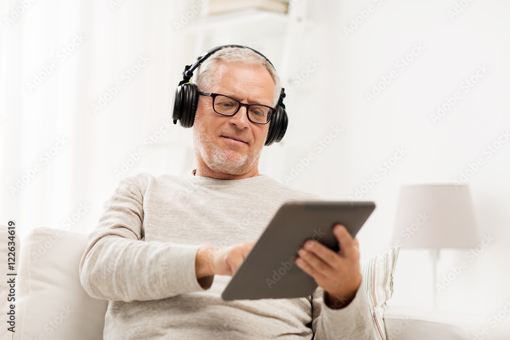 senior man with tablet pc and headphones at home senior man with tablet pc and headphones at home