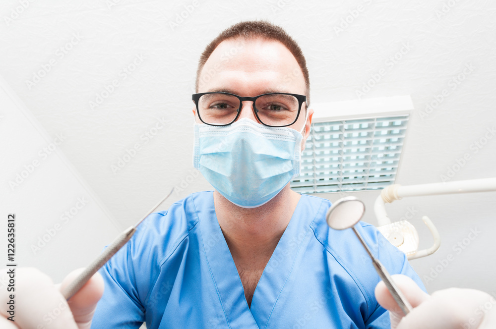 Hygienist wearing mask making consultation holding tools Hygienist wearing mask making consultation holding tools