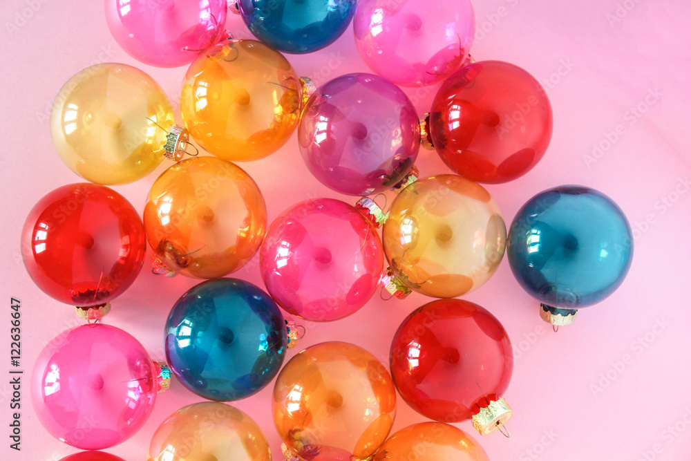 Colourful translucent glass Christmas baubles on pink background. Creative decoration. Top view Colourful translucent glass Christmas baubles on pink background. Creative decoration. Top view