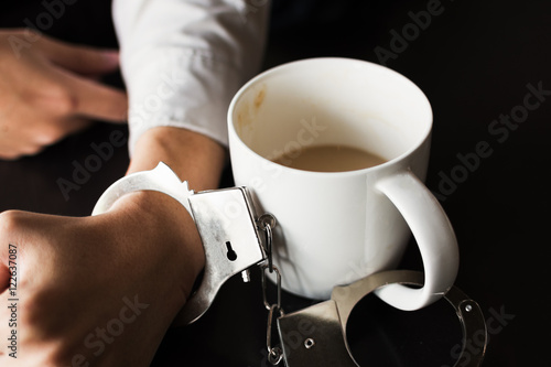 Foto handcuffs with with cup of coffee..maniac caffeine addiction con