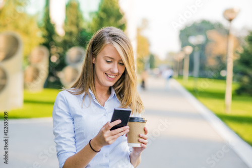 business, communication, technology and people concept - young women smiling and talking on the smarphone