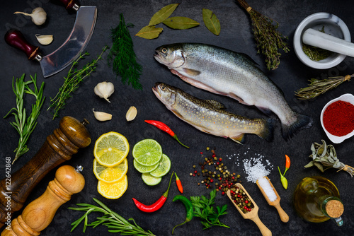 Canvas Print Trout Fish with Cooking ingredients on Dark Background