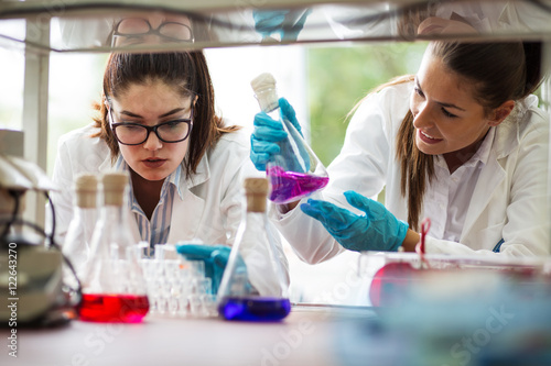 Two young female scientist doing experiments in lab.