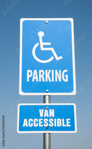 Handicapped parking sign against clear blue sky