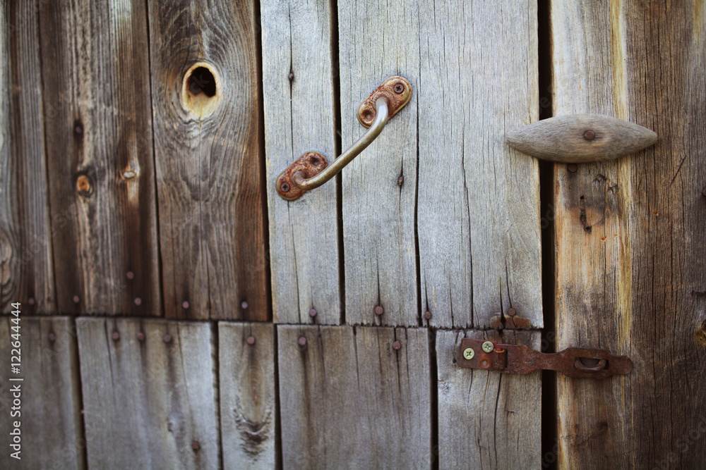 Old rusty lock hanging on the gray wooden door. Old rusty lock hanging on the gray wooden door.
