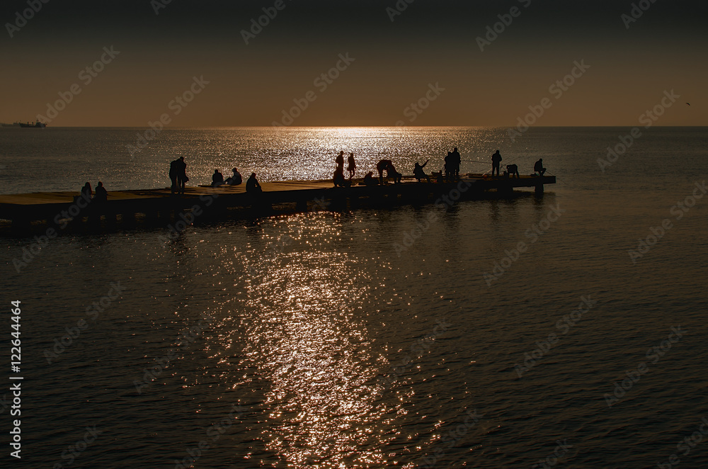 Fishing after sunset, the ocean in golden light Fishing after sunset, the ocean in golden light