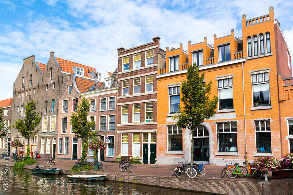 Row of historic houses and warehouses on quay of Old Rhine canal in old town of Leiden, South Holland, Netherlands
