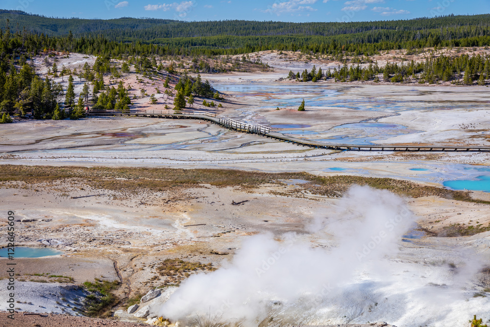 The boardwalk among pools and geysers. The barren snow-colored basin. Porcelain Basin of Norris Geyser Basin, Yellowstone National Park, Wyoming