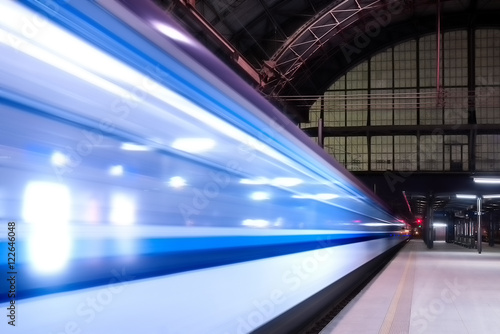 Train speeding through Prague railway station during busy night time with extended motion. Beautiful historical railway station in capital city of Czech republic.