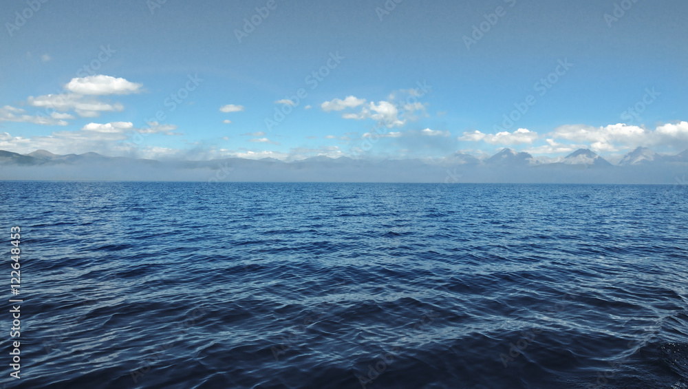 sea lanscape. blue sky, clouds over the surface of sea. mountain on horizon sea lanscape. blue sky, clouds over the surface of sea. mountain on horizon